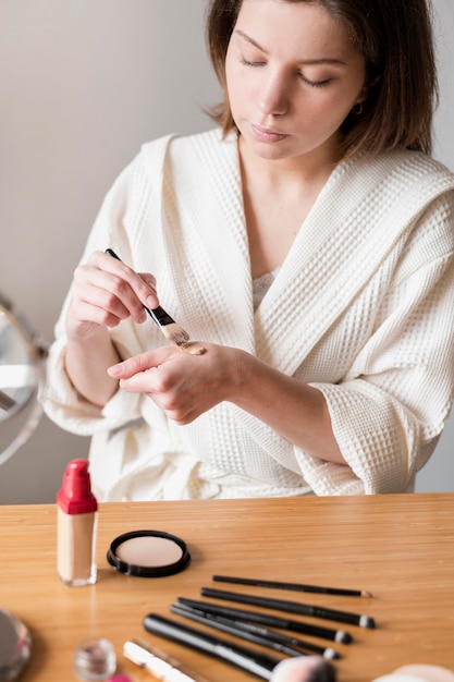 Woman using brush for foundation