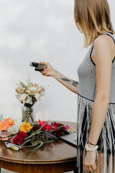 Woman using a camera to take a picture of colorful flowers