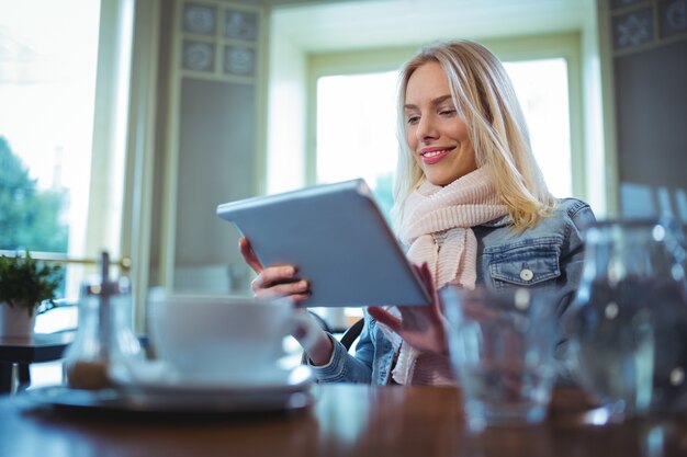 Woman using digital tablet in cafe