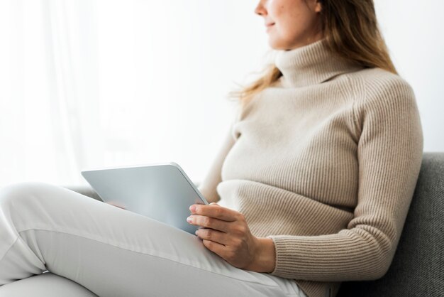 Woman using digital tablet on a couch