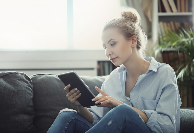 デジタルタブレットやスマートフォンを使用して女性