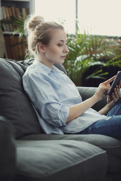 デジタルタブレットやスマートフォンを使用して女性