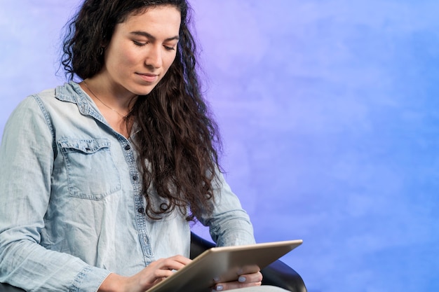 Foto gratuita donna che per mezzo di una compressa digitale