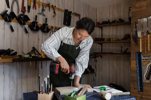 Woman using drill medium shot