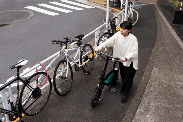 Женщина, использующая электрический велосипед в городе