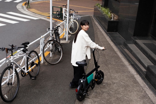Женщина, использующая электрический велосипед в городе