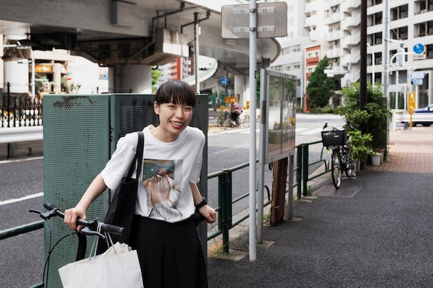 무료 사진 도시에서 전기 자전거를 사용하는 여자