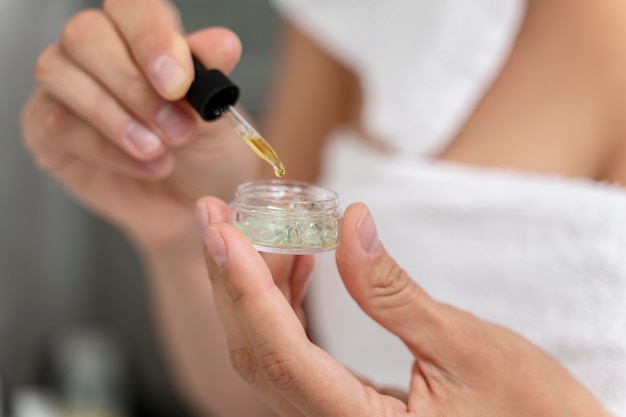 Woman using face oil with a dropper