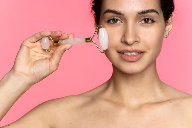 Woman using face roller front view