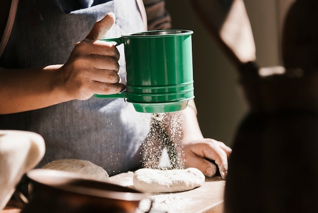 Woman using green flour sieve