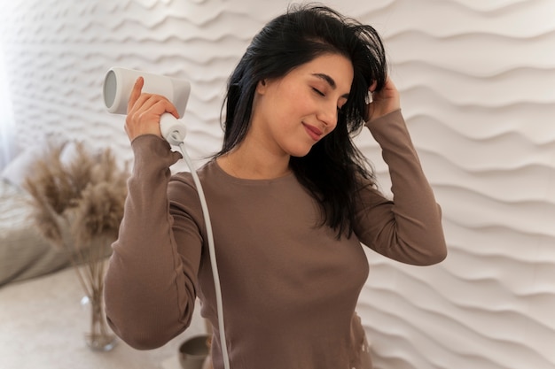 Woman using hairdryer during her beauty routine