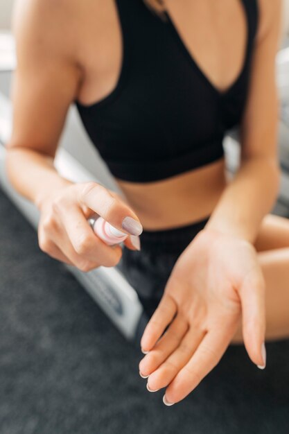 여자는 체육관에서 운동하기 전에 손 소독제를 사용