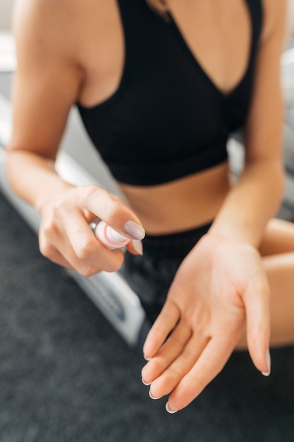 Woman using hand sanitizer before working out at the gym