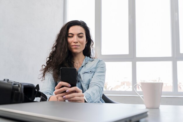 ビジネスオフィスで彼女の携帯電話を使用しての女性