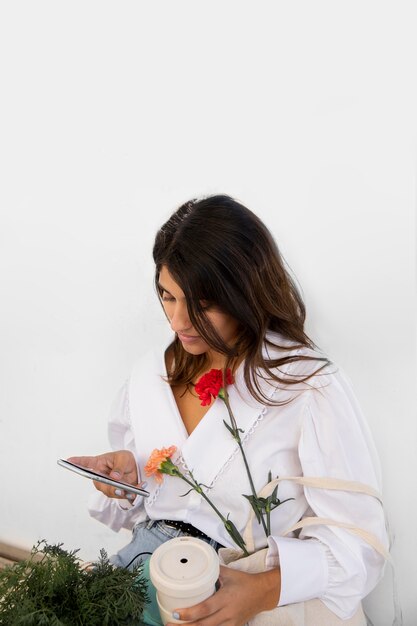 Woman using her smartphone outdoors while having coffee