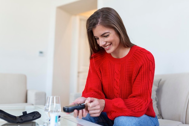 Foto gratuita donna che usa la lancetta sul dito donna che esegue il test della glicemia a casa in un soggiorno