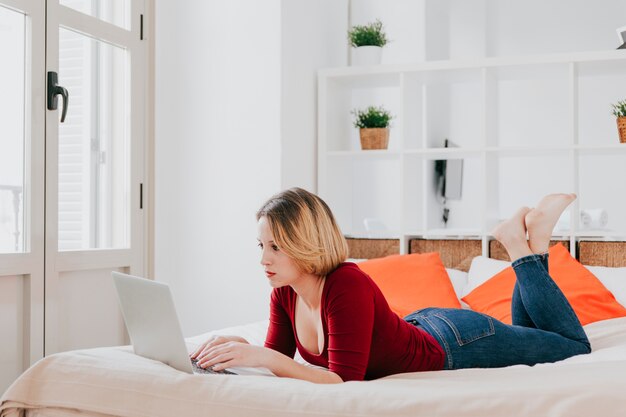 Woman using laptop on bed