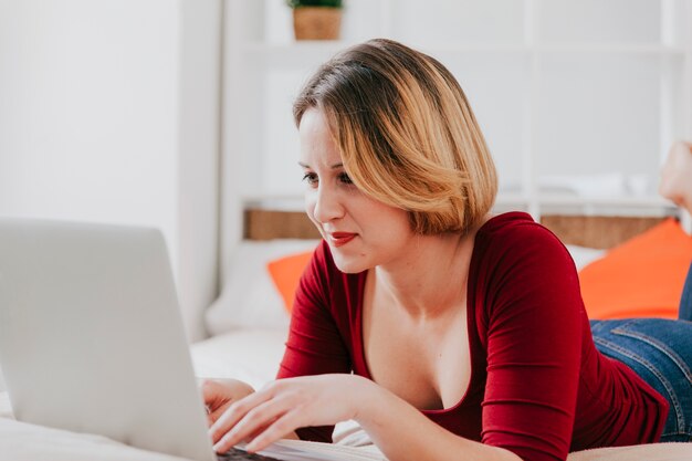 Free photo woman using laptop on bed