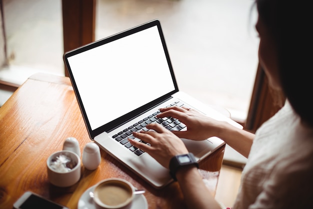 Woman using laptop in café