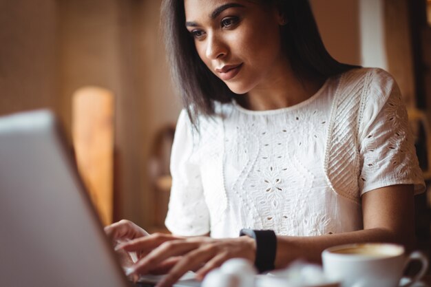 Woman using laptop in café