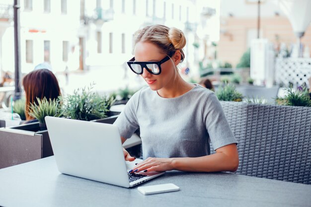 Женщина, используя ноутбук в кафе