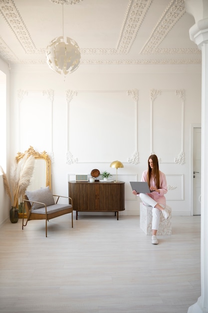 Foto gratuita donna che usa il computer portatile in una stanza decorata minima