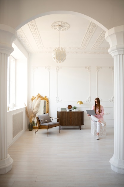 Woman using laptop in minimal decorated room