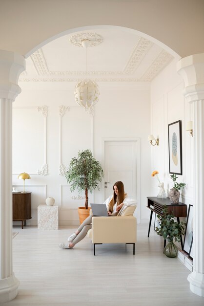 Woman using laptop in minimal decorated room