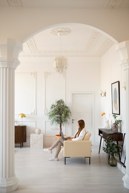 Woman using laptop in minimal decorated room