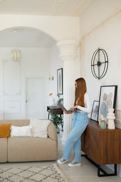 最小限の装飾が施された部屋でラップトップを使用している女性