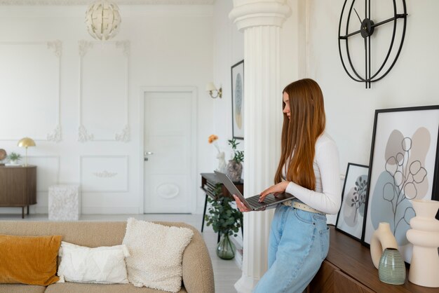 最小限の装飾が施された部屋でラップトップを使用している女性