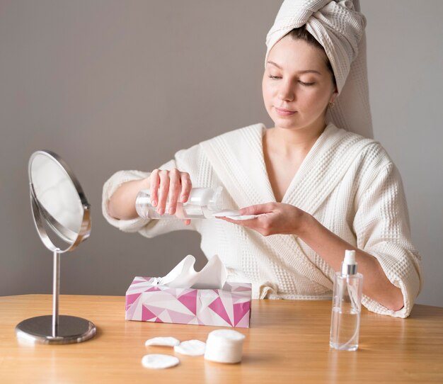 Woman using micellar water to cleanse