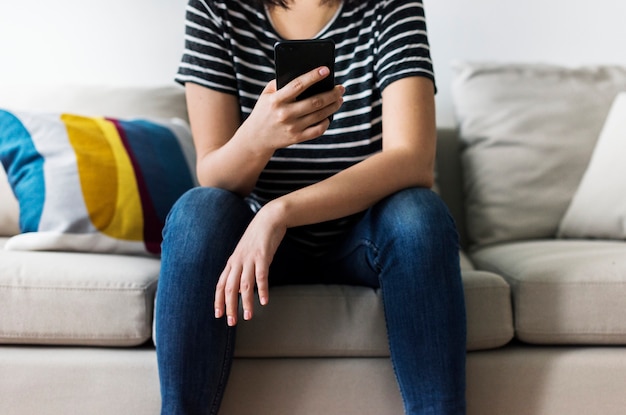 Woman using mobile phone on the couch