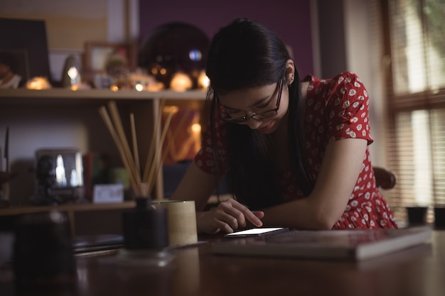 Free photo woman using mobile phone on table