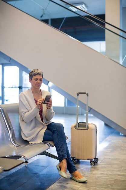 Woman using mobile phone in waiting area