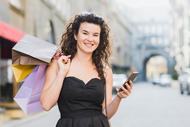 ストリートで買い物をしながら携帯電話を使っている女性