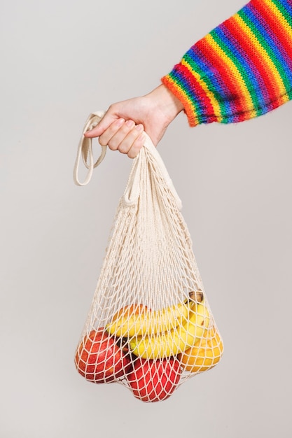 果物を運ぶためにネットバッグを使用している女性