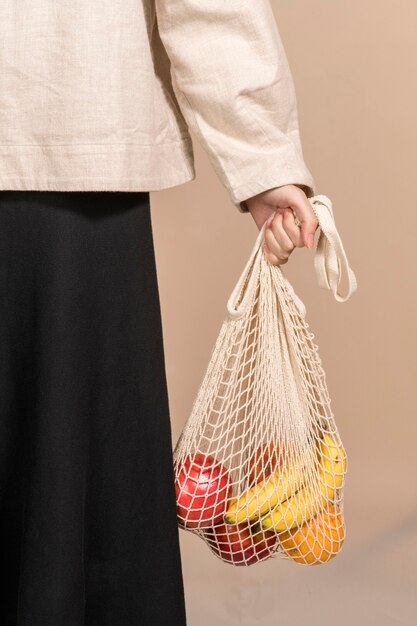 Woman using a net bag to carry fruits