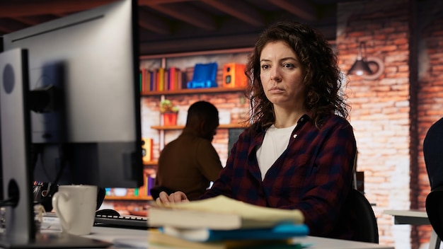 woman using pc in startup office to design and implement algorithms