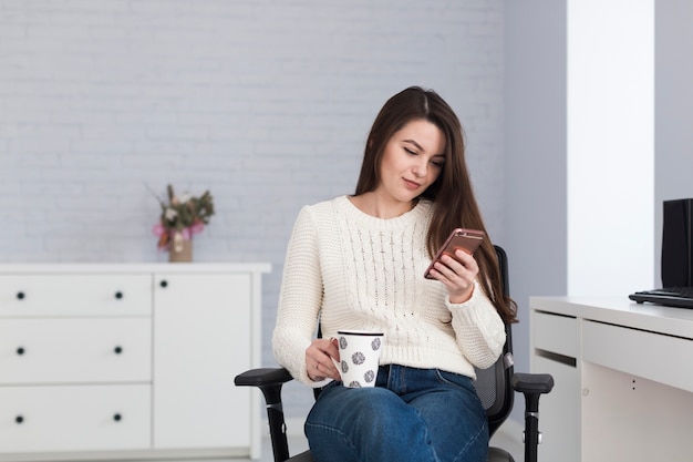 Donna che utilizza telefono in ufficio