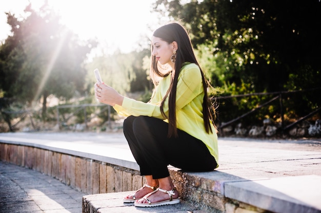 Woman using phone on steps