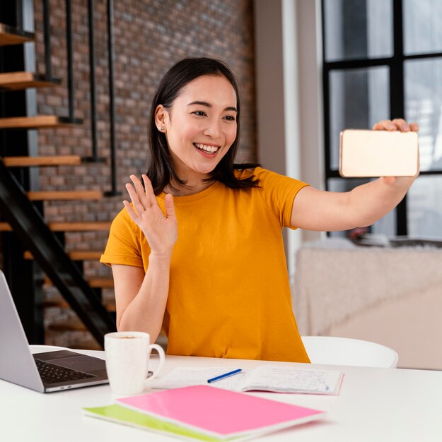 Woman using phone while attending online class