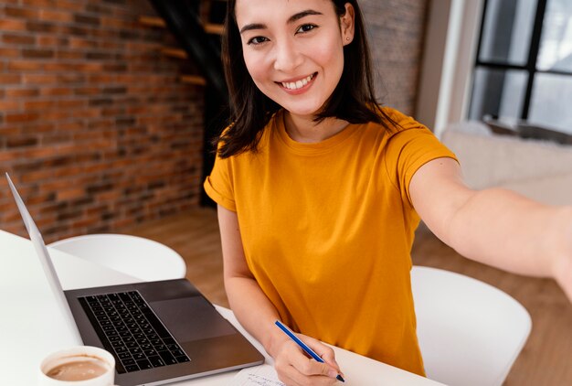 Free photo woman using phone while attending online class