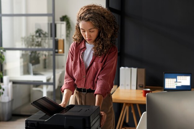 Woman using printer medium shot