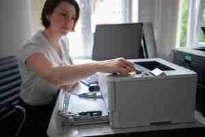 Foto gratuita donna che utilizza la stampante in ufficio