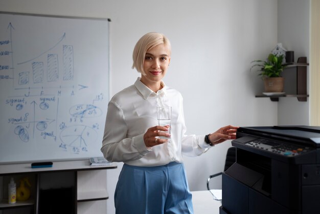 사무실에서 일하는 동안 프린터를 사용하는 여성