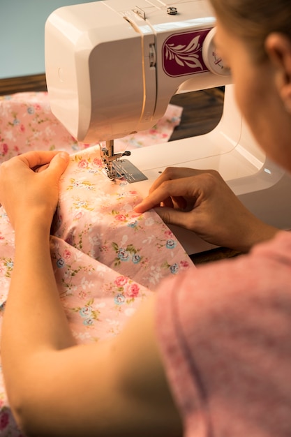 Free photo woman using sewing machine on flowery pattern