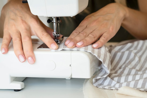 Женщина с помощью швейной машины на ткани