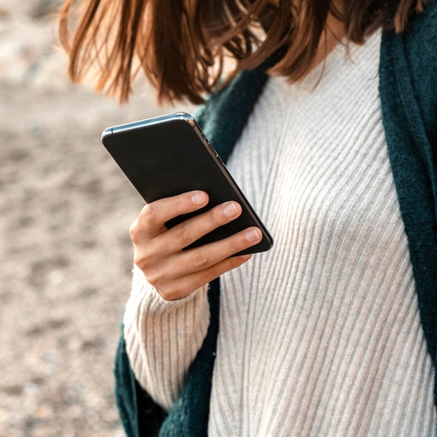 Donna che utilizza smartphone in spiaggia