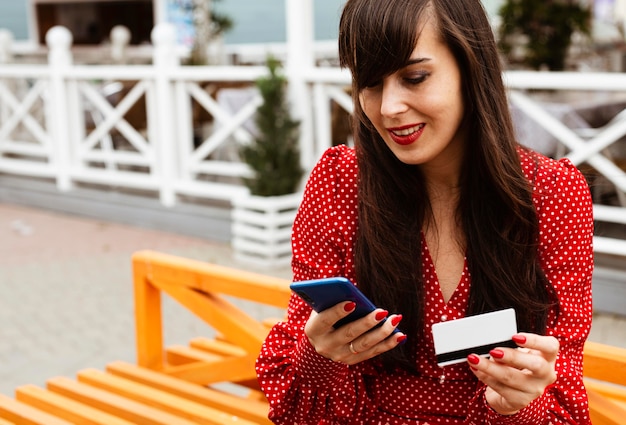 Woman using smartphone and credit card to shop sales online